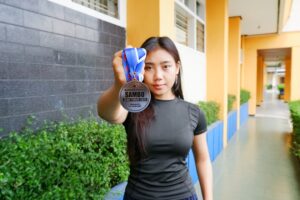 Refi Marinda, mahasiswa Teknik Geodesi ITN Malang memperlihatkan medali perak Kejuaraan Provinsi (Kejurprov) Sambo Jawa Timur 2025.