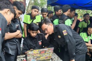 Dhaniel Danuarta D., alumnus Teknik Mesin D-3 ITN Malang angkatan 2020 (berkacamata) memandu siswa untuk setting ECU