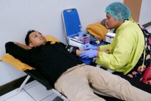 Petugas medis Unit Donor Darah PMI Kota Malang dengan cermat melakukan proses pengambilan darah dari pendonor di Aula Kamps 1 ITN Malang