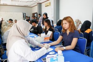 Seorang mahasiswi ITN Malang antusias mengikuti tahapan pemeriksaan gula darah gratis yang diselenggarakan oleh petugas Dinkes Kota Malang.